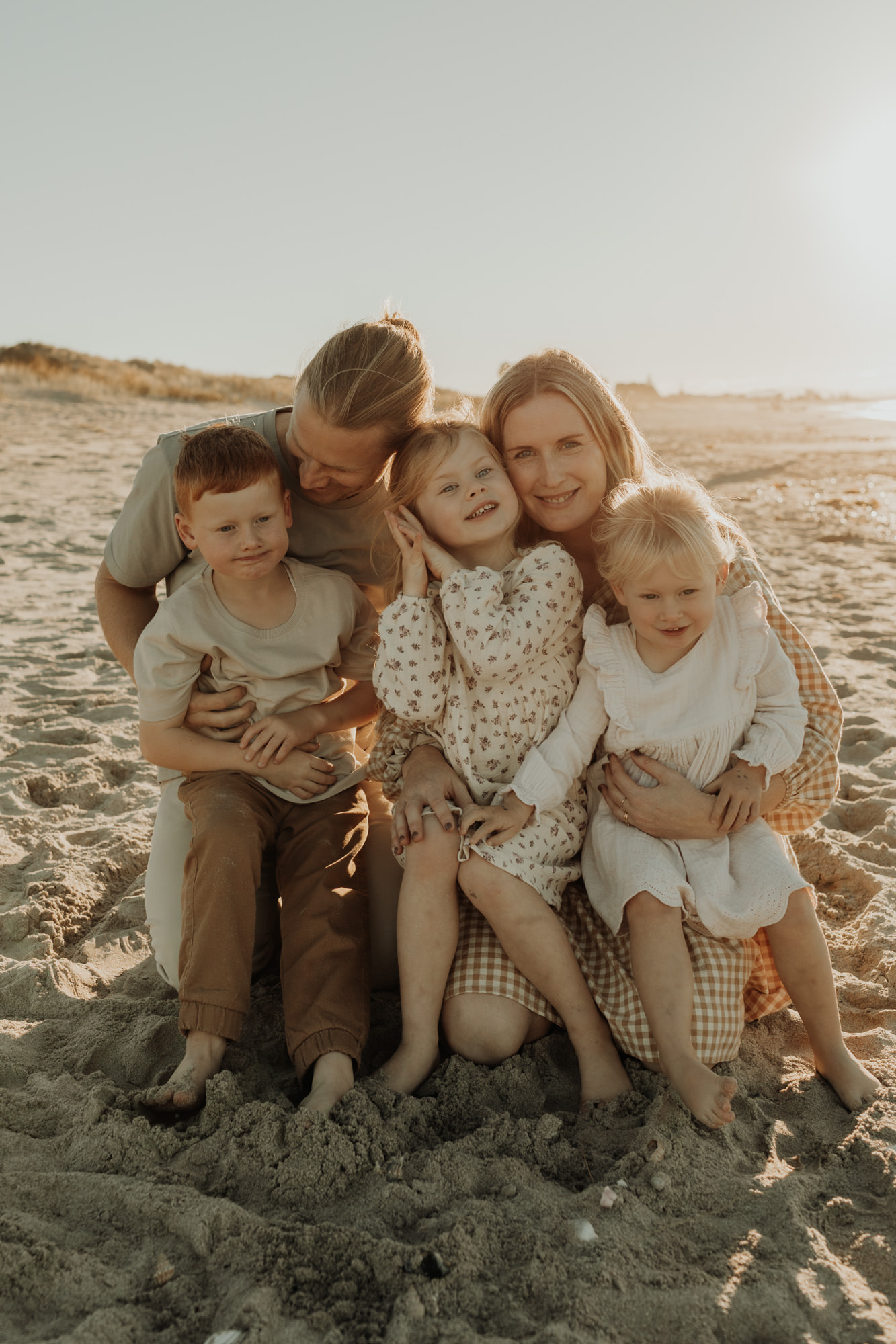young family of 5 on papamoa beach during sunset photoshoot
